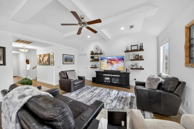 a living room with furniture and a dining table with kitchen view