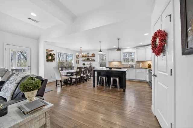 a kitchen with granite countertop a dining table chairs and white cabinets