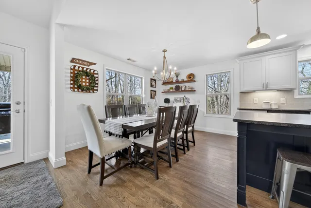 a kitchen with kitchen island granite countertop a center island stainless steel appliances cabinets and a wooden floor