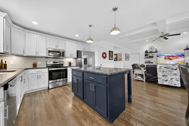 a kitchen with white cabinets and appliances