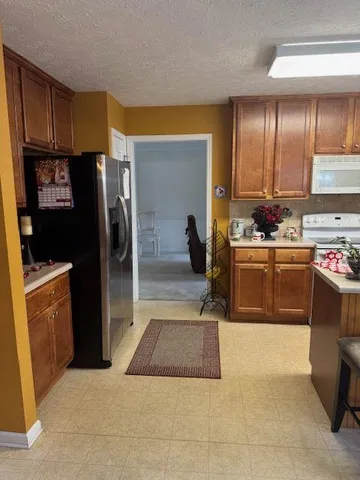 a kitchen with stainless steel appliances granite countertop a stove a refrigerator and a sink