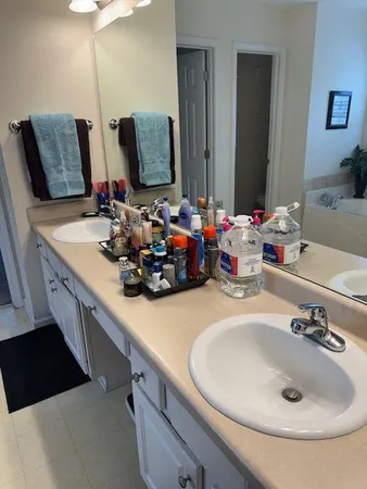 a bathroom with a double vanity sink and a mirror