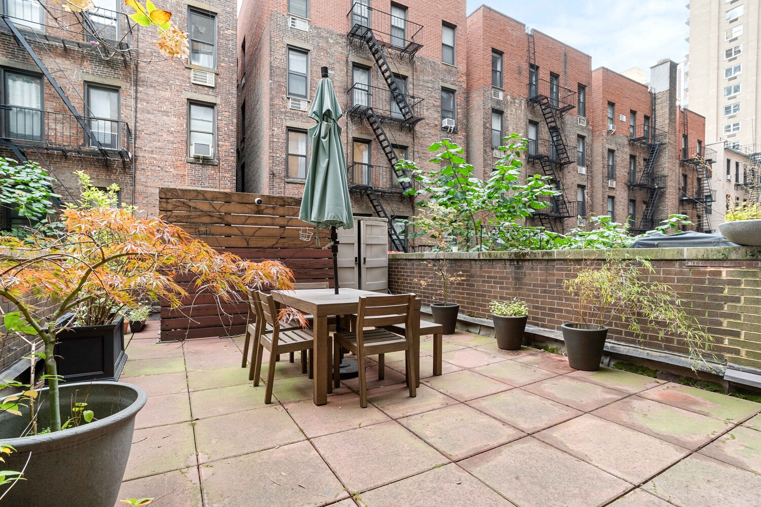 225 East 86th Street, Unit 204 Manhattan, NY 10028 - Photo 11 of 17 a view of a patio with table and chairs and potted plants