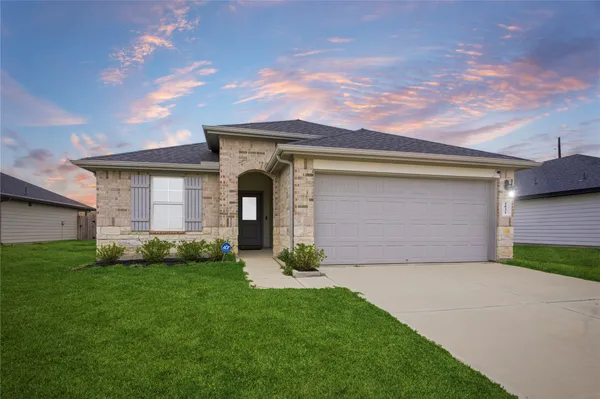 a front view of a house with a garden and garage