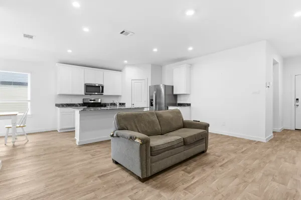 a living room with furniture and kitchen view