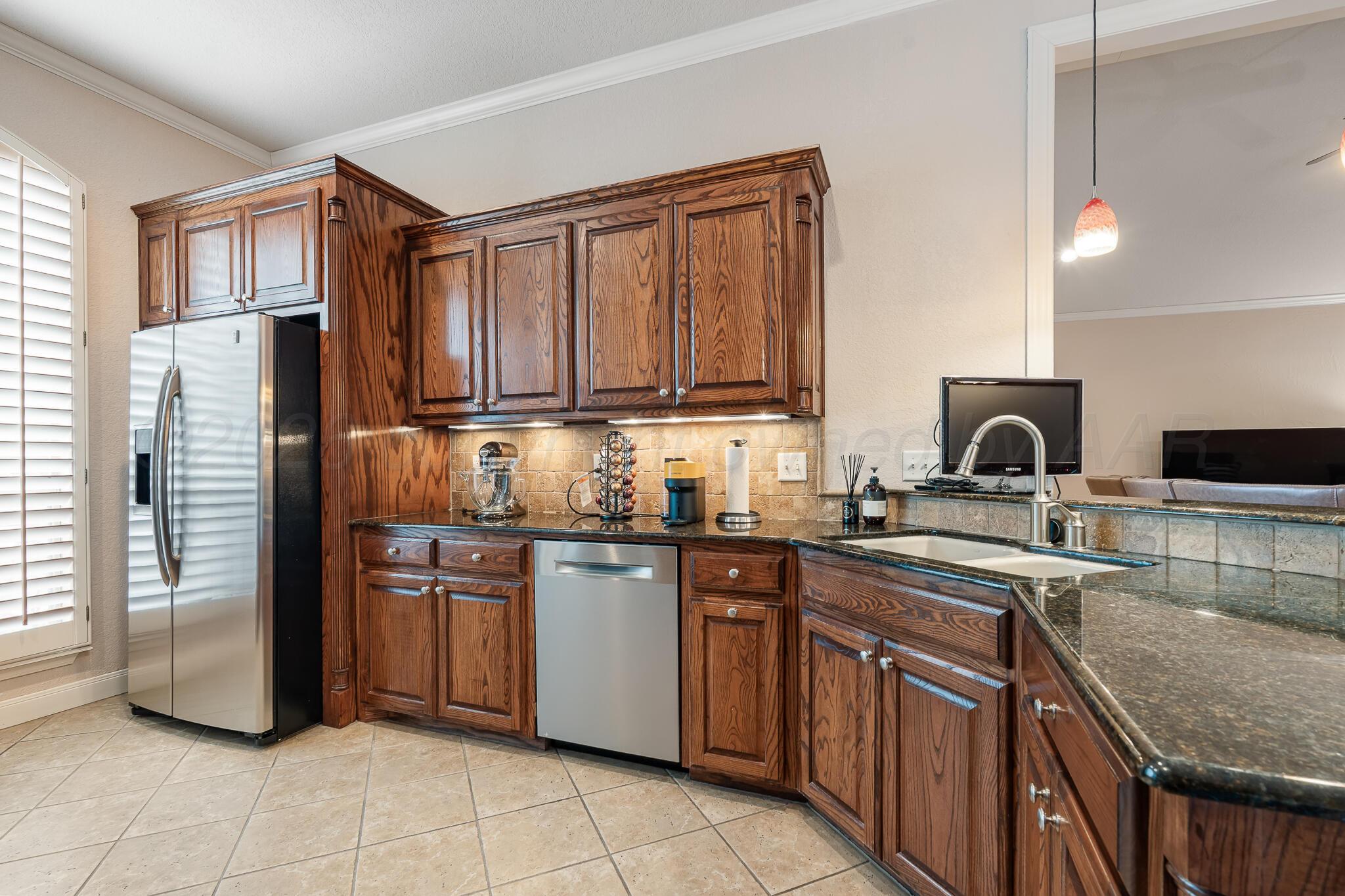 5008 Wesley Road Amarillo, TX 79119 - Photo 12 of 47 a kitchen with stainless steel appliances granite countertop a sink stove and refrigerator