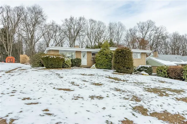 a view of a house with a yard covered in snow