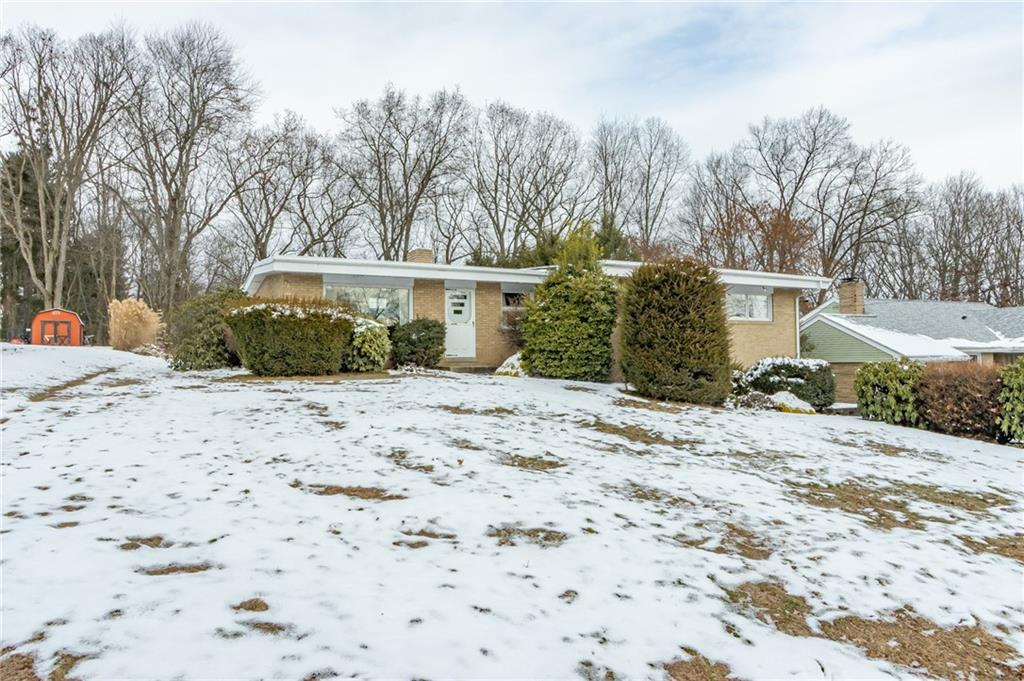 a view of a house with a yard covered in snow