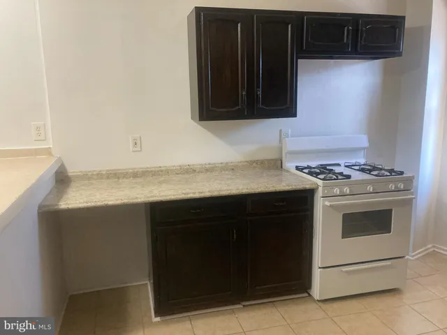 a kitchen with granite countertop a stove and a microwave