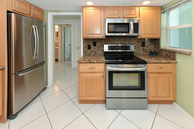 a kitchen with stainless steel appliances granite countertop a stove a refrigerator and a microwave