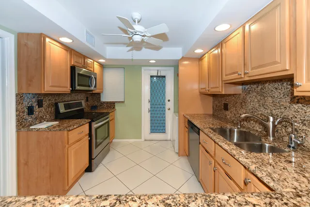 a kitchen with stainless steel appliances granite countertop a stove a sink and a microwave