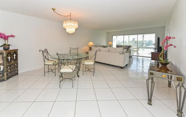 a living room with furniture a floor to ceiling window and a flat screen tv