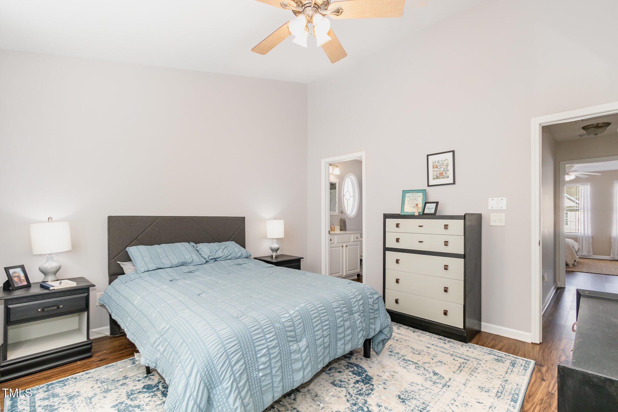 7621 Satinwing Lane Raleigh, NC 27617 - Photo 12 of 23 a bedroom with a bed and a chandelier