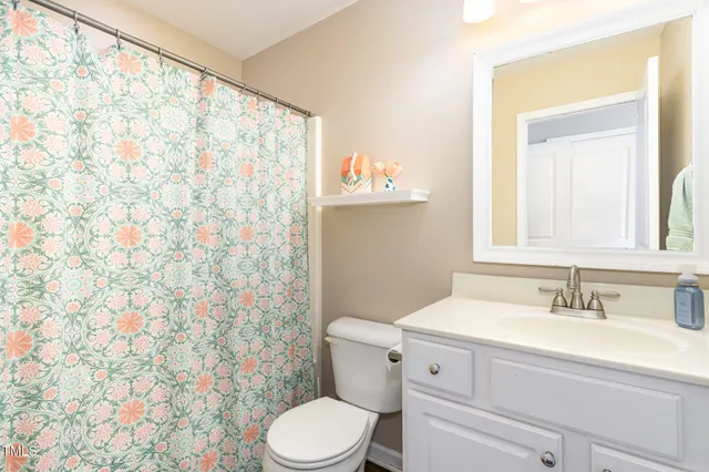a bathroom with a sink a toilet and shower curtain