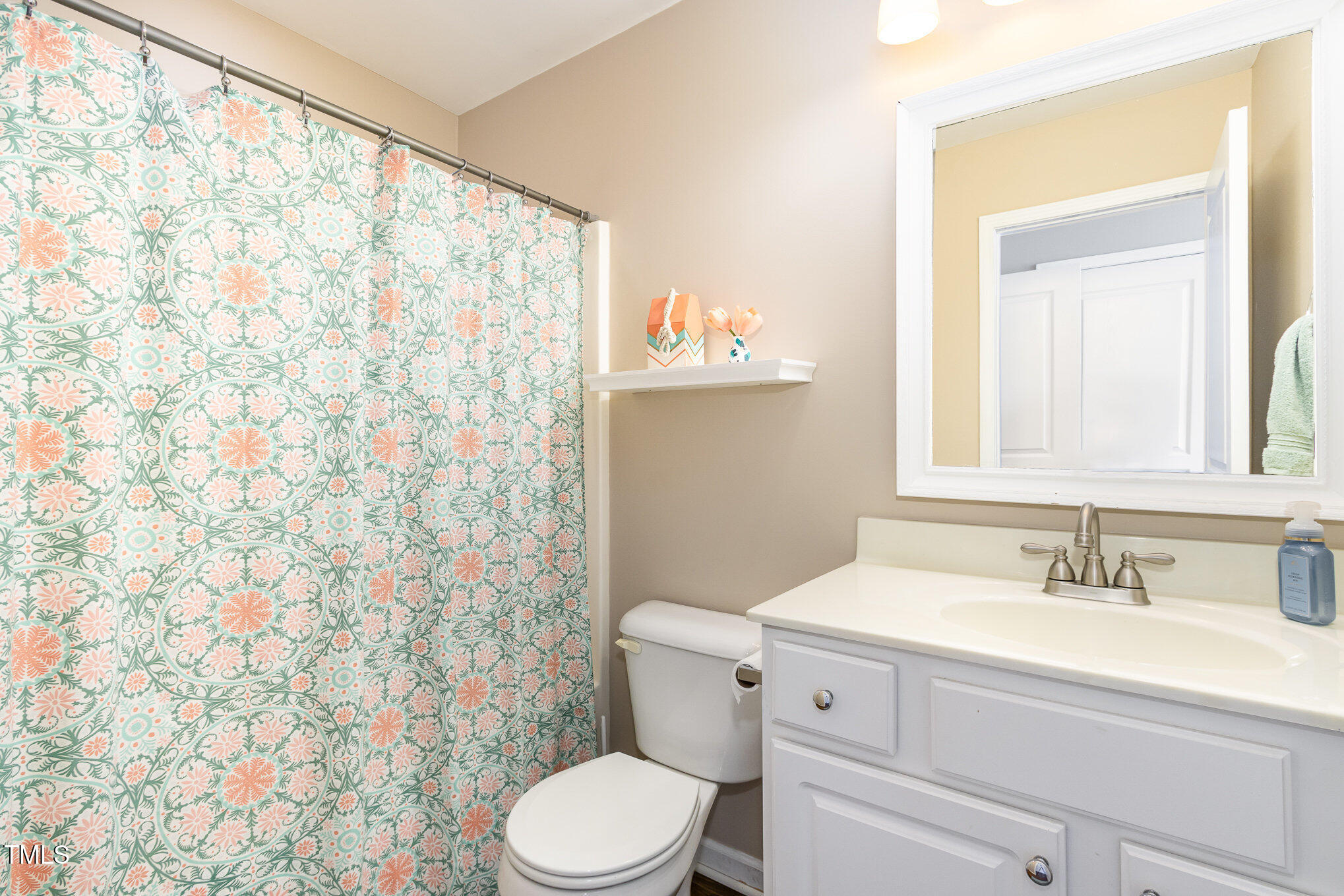7621 Satinwing Lane Raleigh, NC 27617 - Photo 17 of 23 a bathroom with a sink a toilet and shower curtain