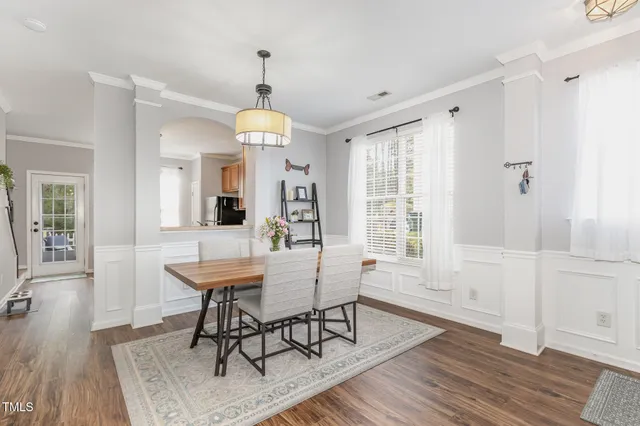 a view of a a dining room with furniture window and wooden floor