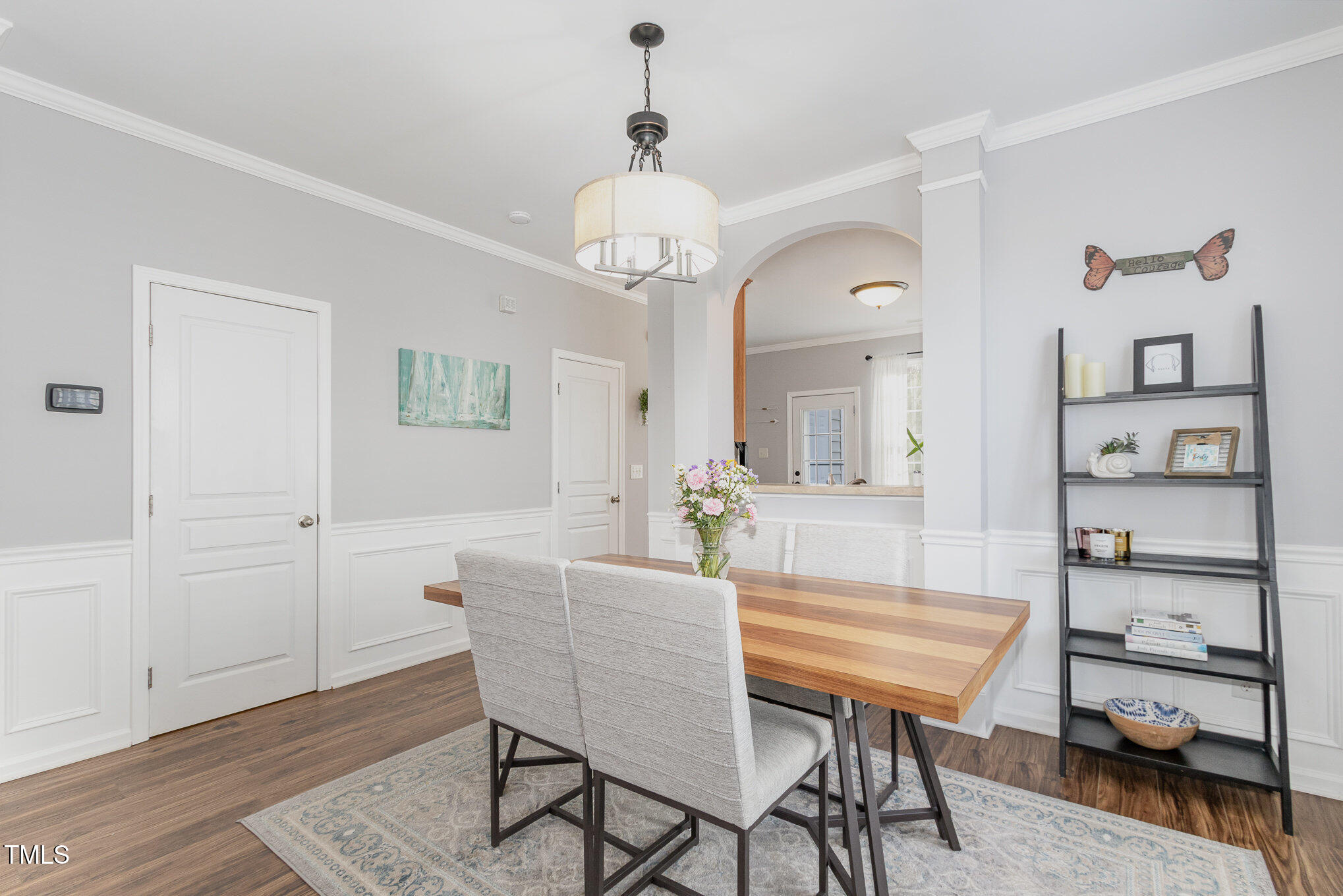 7621 Satinwing Lane Raleigh, NC 27617 - Photo 6 of 23 a dining room with wooden floor a chandelier a wooden table and chairs