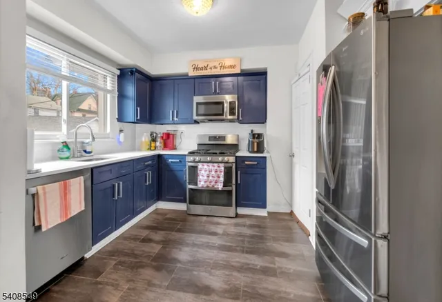 a kitchen with stainless steel appliances granite countertop a refrigerator and a stove