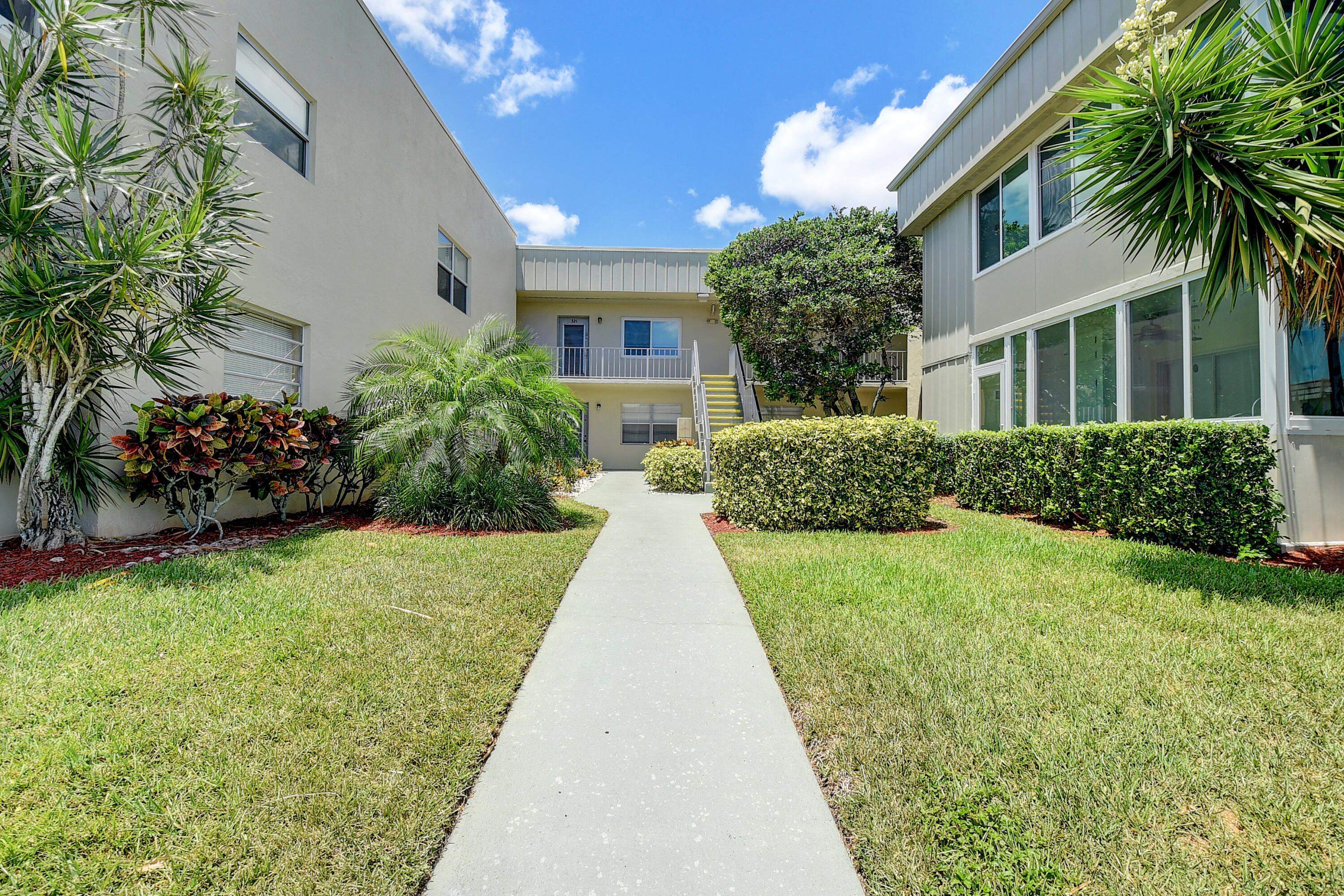 318 Monaco Boulevard, Unit G Delray Beach, FL 33446 - Photo 1 of 31 a view of a house with a garden