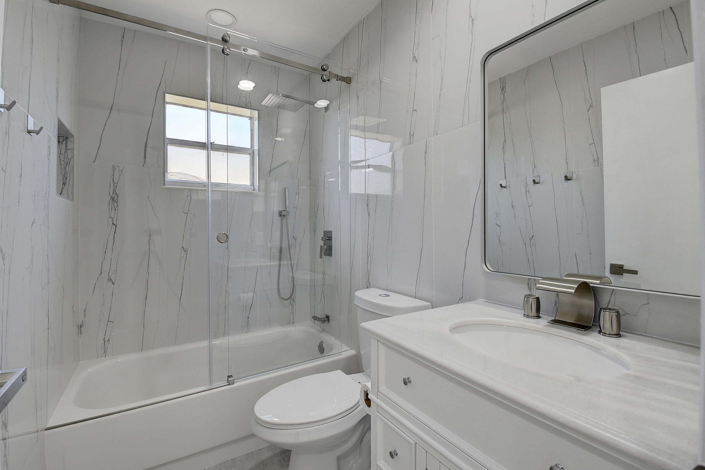 318 Monaco Boulevard, Unit G Delray Beach, FL 33446 - Photo 16 of 31 a bathroom with a granite countertop sink a toilet and shower