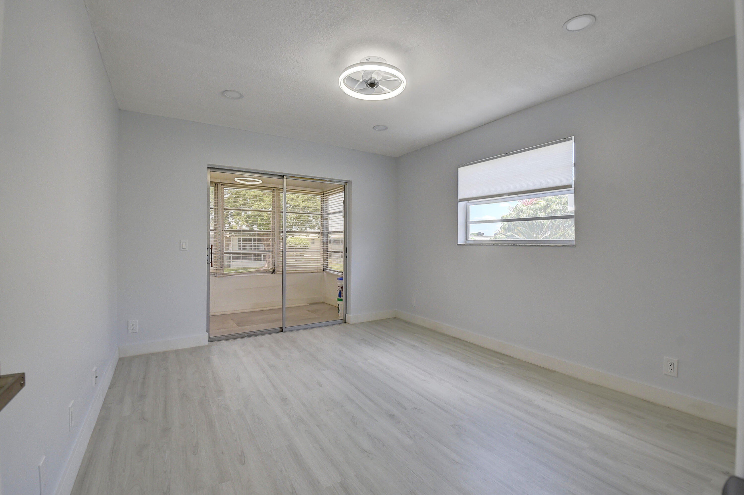 318 Monaco Boulevard, Unit G Delray Beach, FL 33446 - Photo 23 of 31 an empty room with wooden floor and windows