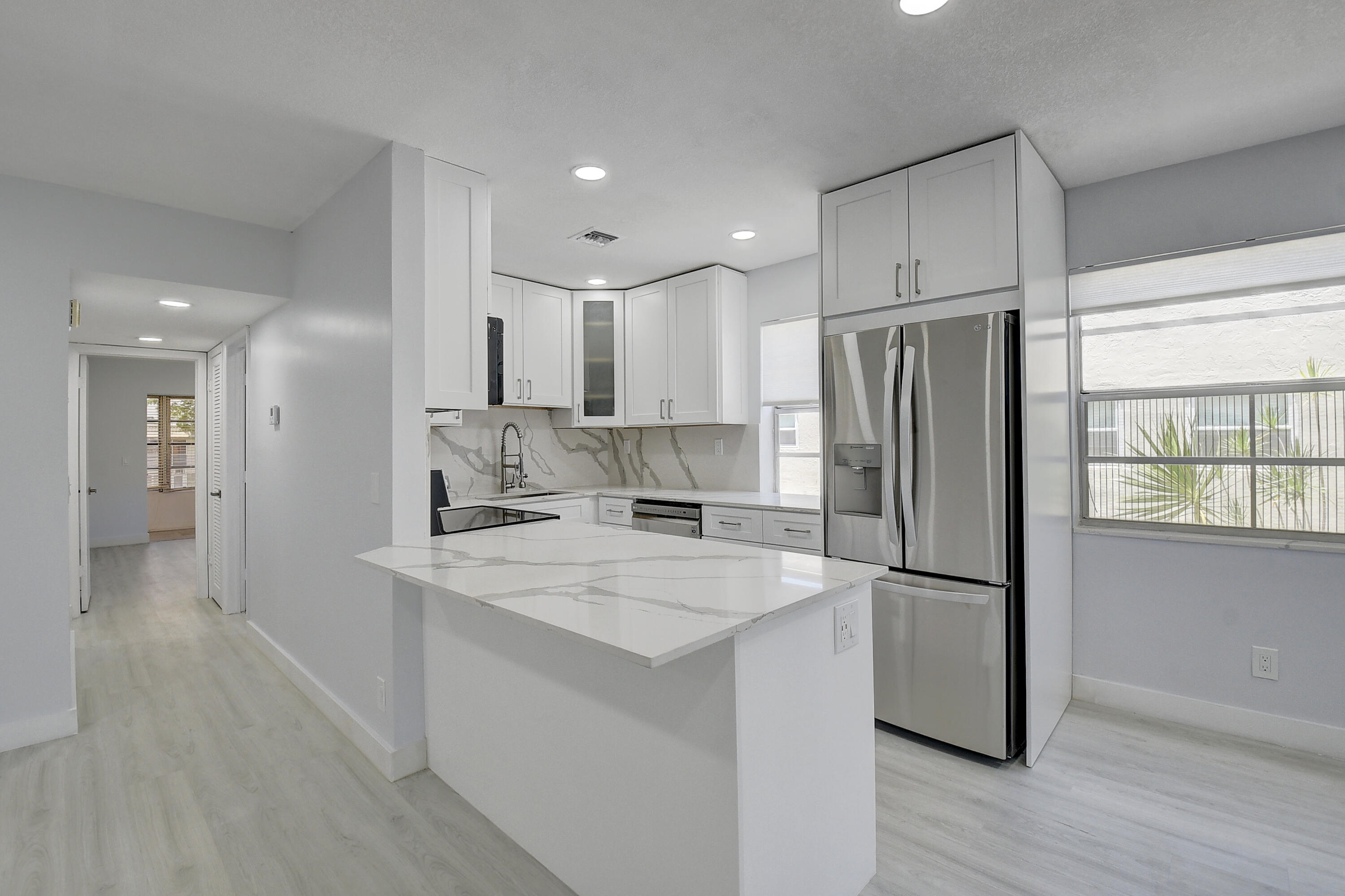 318 Monaco Boulevard, Unit G Delray Beach, FL 33446 - Photo 27 of 31 a kitchen with stainless steel appliances a refrigerator sink and microwave