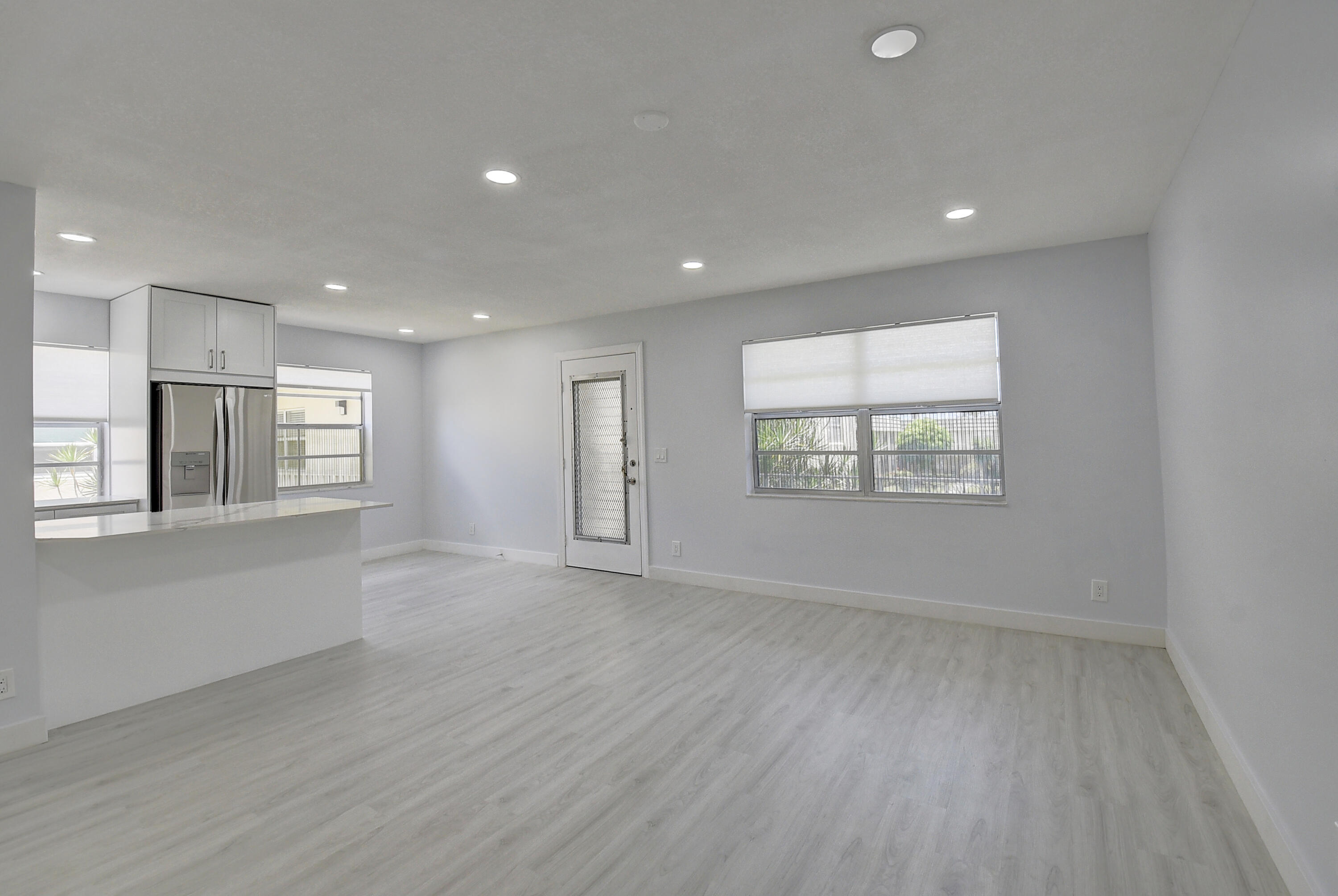 318 Monaco Boulevard, Unit G Delray Beach, FL 33446 - Photo 29 of 31 an empty room with wooden floor and windows