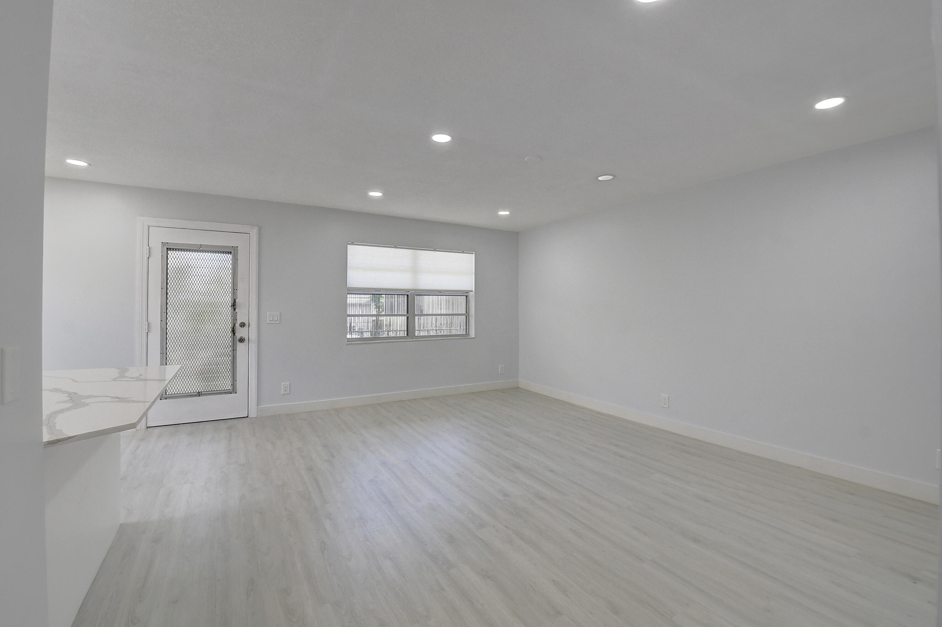 318 Monaco Boulevard, Unit G Delray Beach, FL 33446 - Photo 31 of 31 an empty room with wooden floor and windows