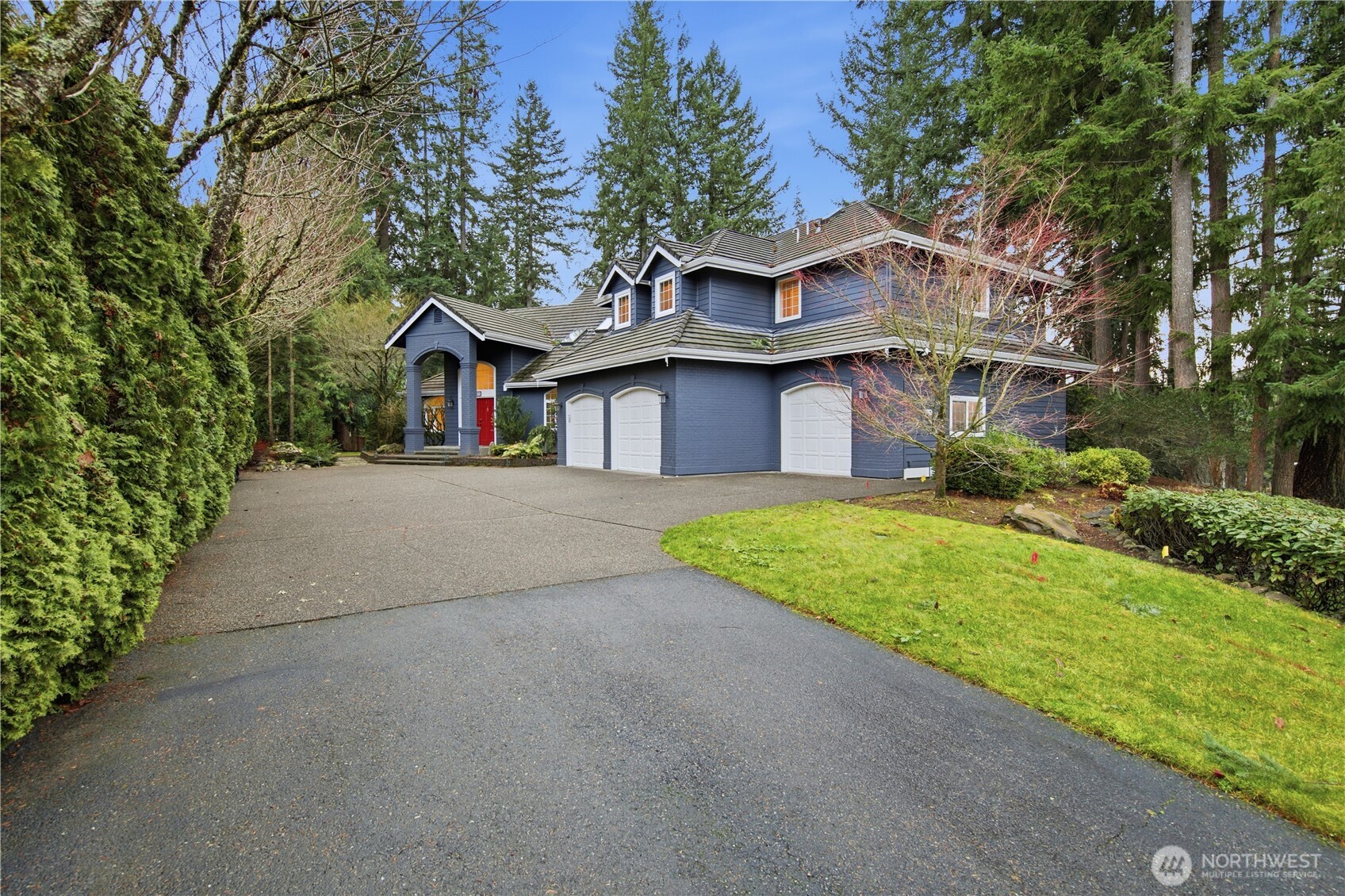 25305 Southeast 232nd Street Maple Valley, WA 98038 - Photo 11 of 33 a front view of a house with a garden and trees