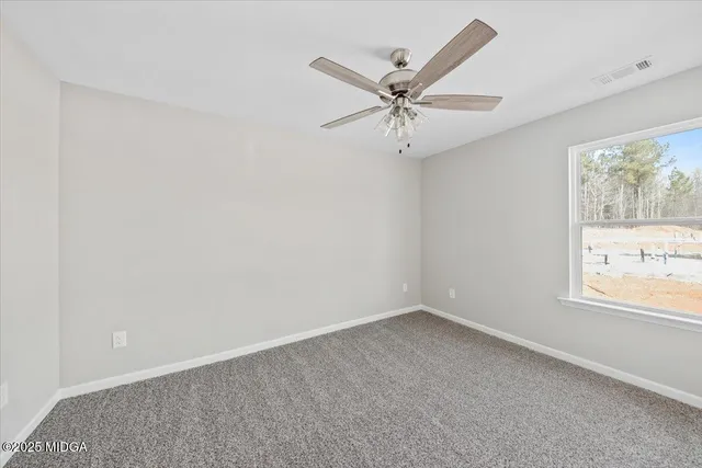 an empty room with a window and a fan