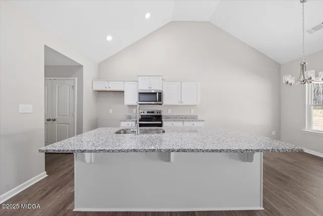 a kitchen with kitchen island granite countertop a sink a granite counter tops and a stove