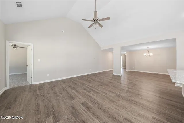 a view of a room with wooden floor and a ceiling fan