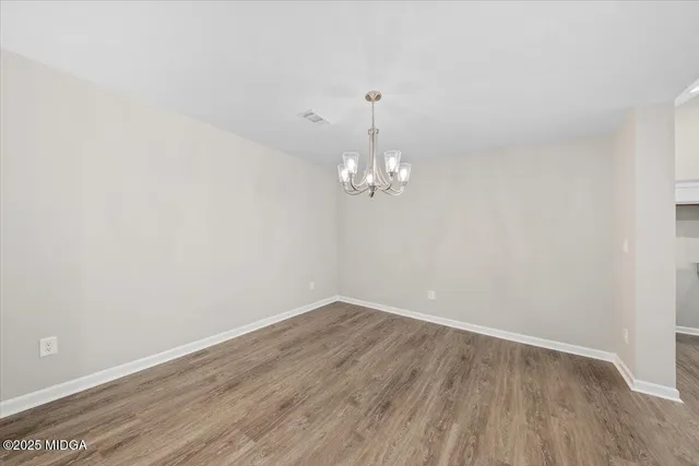 a view of empty room with wooden floor and ceiling fan