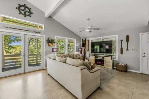 a kitchen with stainless steel appliances kitchen island granite countertop a refrigerator a stove a dining table and chairs with wooden floor