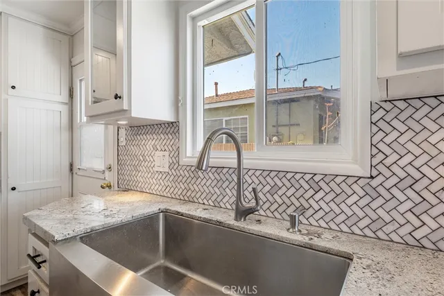 a kitchen with a sink a refrigerator and cabinets