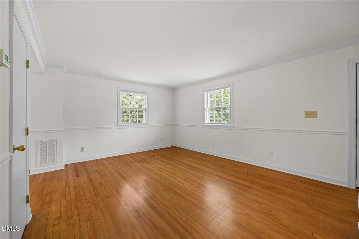 1627 Sutton Drive Raleigh, NC 27605 - Photo 8 of 33 an empty room with wooden floor and windows