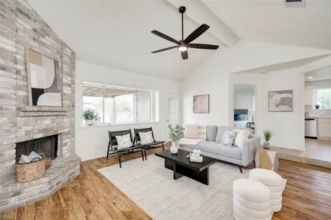 a living room with furniture a fireplace and a large window