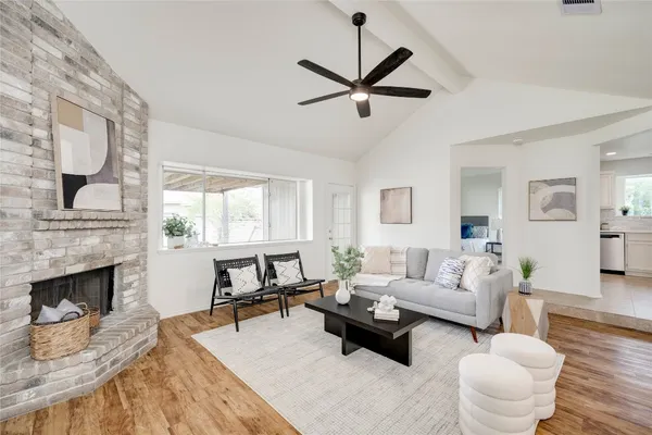 a living room with furniture a fireplace and a large window