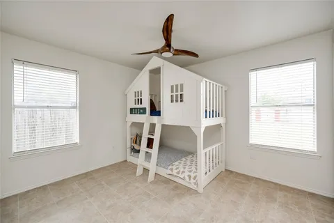 an empty room with windows and ceiling fan