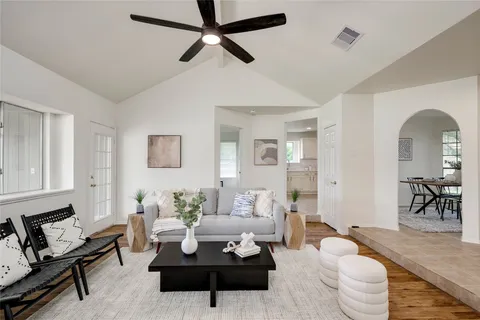 a living room with furniture and a wooden floor