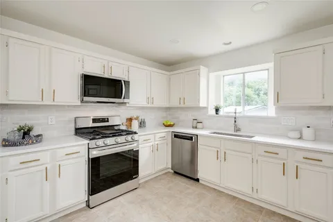 a kitchen with a sink stove and microwave