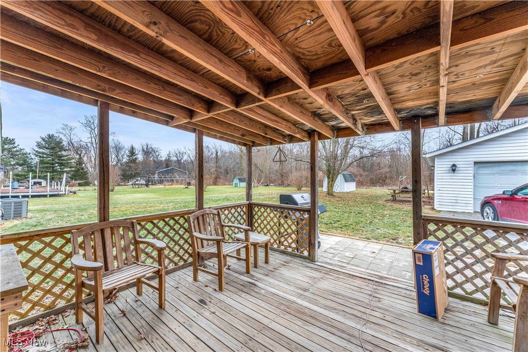 14808 Darrow Road Vermilion, OH 44089 - Photo 38 of 45 Deck featuring central AC, area for grilling, a lawn, and a shed