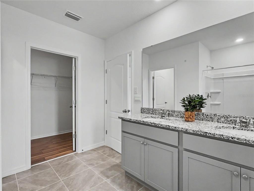 2085 Doe Run Drive Davenport, FL 33837 - Photo 32 of 44 a bathroom with a granite countertop sink and a mirror