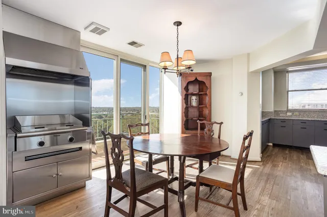 a bathroom with a granite countertop sink a toilet a mirror and next to a window