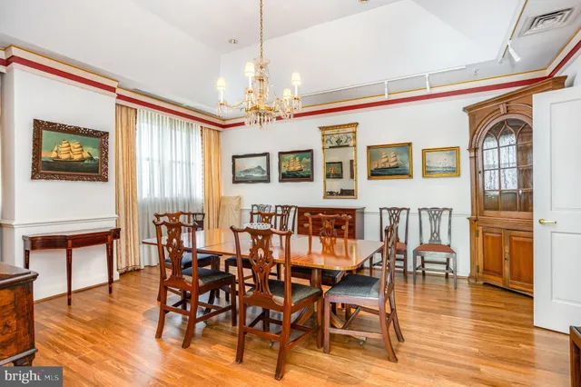 a dining room with furniture large windows and a chandelier