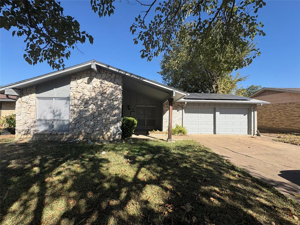 3717 Swallow Lane Irving, TX 75062 - Photo 1 of 11 View of front of property with a front lawn, driveway, a garage, and stone siding