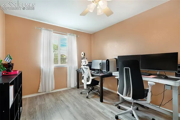 a view of a workspace with furniture and a window