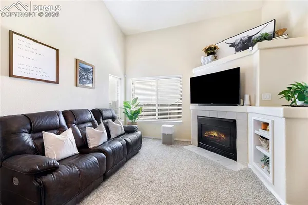 a living room with furniture a flat screen tv and a fireplace