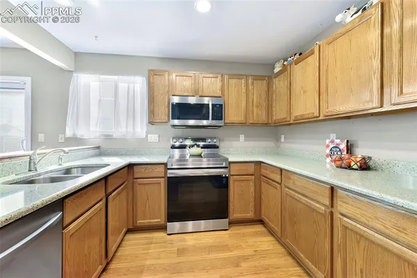 a kitchen with stainless steel appliances granite countertop a sink stove and cabinets