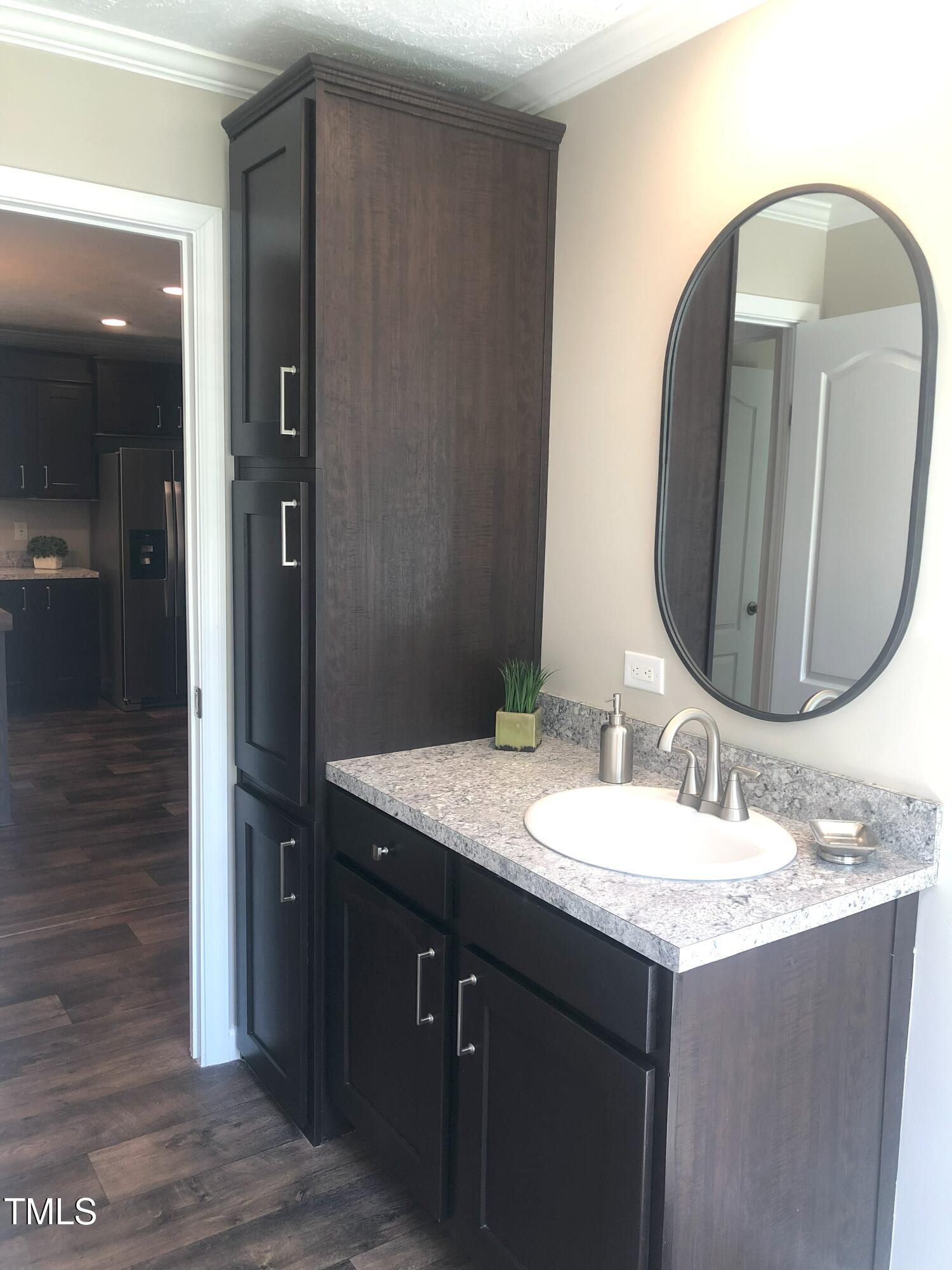 550 Saplin Branch Road Timberlake, NC 27583 - Photo 23 of 33 a bathroom with a granite countertop sink and a mirror